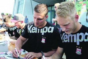 Linksaußen Matthias Musche und Torhüter Dario Quenstedt (v.r.) geben Fans Autogramme und beantworten die Fragen ihrer Anhänger. Foto: Grit Stieger