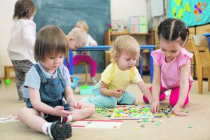 kids or children playing mosaic game in kindergarten room